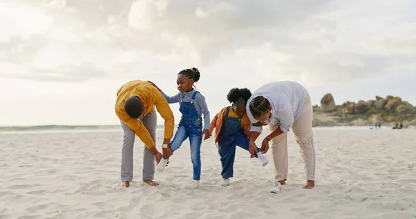Summer, sand and a black family at the beach with shoes for walking or running together. Happy, travel and African children with parents getting ready for playing by the sea during a holiday.