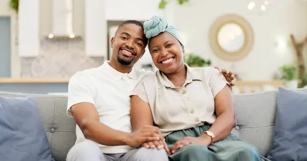 Black couple, love and relax on a home sofa for happiness, bond and care in a living room. Face of an African woman and man together for affection, portrait and hug or comfort in a happy marriage.