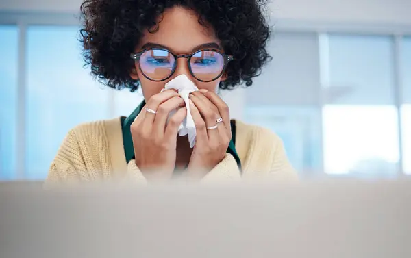 Sick business woman on computer, blowing nose and covid allergy, disease or virus in startup company. Professional, tissue paper and allergies for health problem, cold fever and bacteria in winter.