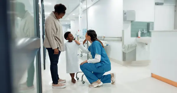 Black family, healthcare and a pediatrician talking to a patient in the hospital for medical child care. Kids, trust or medicine and a nurse consulting a boy with his mother in the clinic for health.