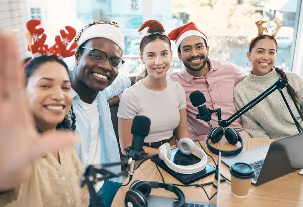 Christmas portrait, podcast and group selfie of friends, live streaming and people recording broadcast together in studio. Smile, radio host team and picture for xmas at table, holiday or celebration.