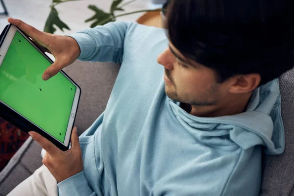 タブレット グリーンスクリーン 上から家のリビングルームでソファーでゲームをしている男 エンターテイメントのためのマーカーを追跡するディスプレイまたはスクリーンを使用して技術 ゲーム 若いゲーマー — ストック写真