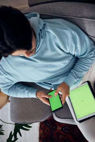 绿色屏幕和一个男人在他家客厅的沙发上玩游戏 使用带有跟踪标记的显示屏或屏幕进行娱乐的平板电脑 游戏和年轻游戏玩家 — 图库照片