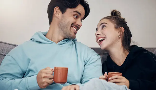 Couple, coffee and relax with smile, love and trust on sofa in living room of home or apartment with bonding. Tea, man and woman together with happiness for peace, romance and commitment on couch.