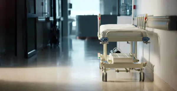Healthcare, medicine and a bed in the corridor of a hospital after work, ready for an emergency or accident. Medical, wellness and service with a gurney in the empty hallway of a health clinic.