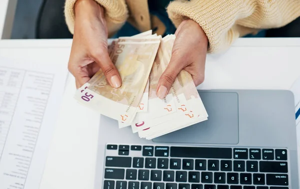 Money, hand and business woman with laptop in office for budget, savings and investment from above. Cash, counting and lady investor with payment, loan or sale, deal and profit, growth or management.