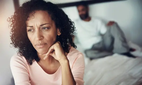 Divorce, sad and couple in bedroom for problem, depression and marriage fail and mental health risk. Thinking, fight and woman with man, conflict and home depressed with anxiety, frustrated or stress.