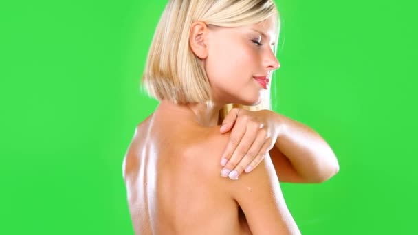 根据工作室背景 在绿色屏幕上对女性 乳霜和护肤产品进行防晒 美容或化妆品护理 在造型上放松地涂上乳液 乳霜或润肤剂的金发女子或模特 — 图库视频影像