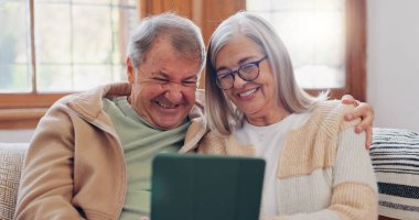 Tablet, sohbet ve sosyal medya ağındaki koltukta oturan yaşlı çift. Emeklilik parşömenindeki dijital teknoloji, bağlanma ve yaşlılara mobil uygulama ya da evdeki internet.