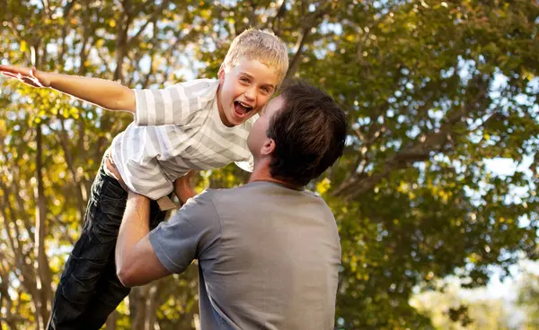 Father, child and backyard with airplane game, happy bonding and fun morning playing for dad and son. Outdoor fun, love and playful energy, man holding boy in air and laughing in garden together