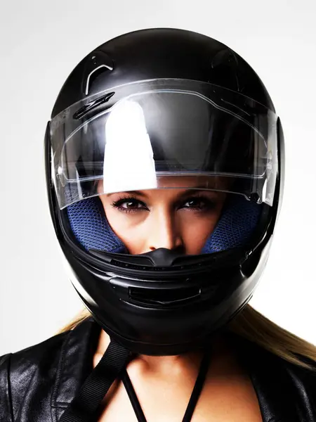 Motorbike helmet, portrait and sexy woman in studio isolated on white background. Biker, face and safety of serious girl, sports protection and fashion style, motorcyclist racer and beauty of driver.