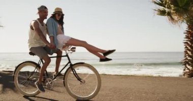 Seyahat, sahil ve sokakta bisiklete binen bir çift. Aşk, romantizm ya da tropikal bir randevu için. Yaz, gülümse ya da bir erkekle mutlu ol. Okyanus ya da deniz kenarında bisiklete binip bağ kur..