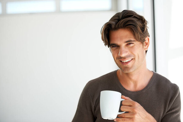 Portrait, smile and man with coffee in home for breakfast, warm beverage or relax in morning with mockup space. Happy guy enjoy drinking mug of fresh caffeine, cappuccino or hot espresso in apartment.