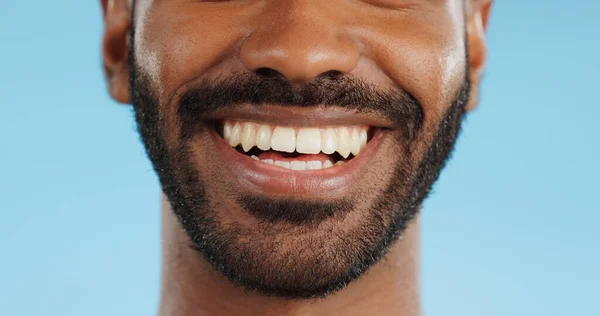 Smile, closeup and black man with teeth in studio, blue background and mockup space with happiness or advertising. Portrait, closeup and marketing for skincare, wellness or healthy dermatology care.