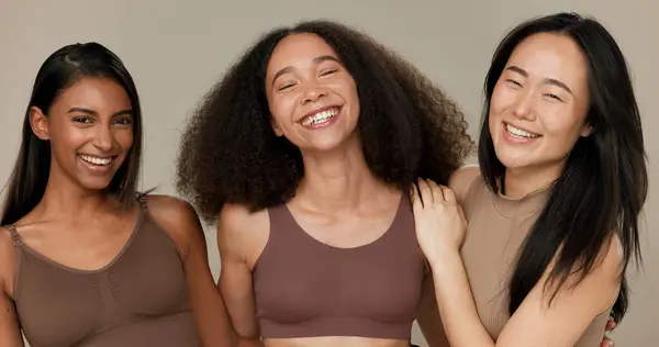 Diversity, underwear and portrait of women friends in studio for beauty, inclusion or wellness. Happy people hug on neutral background as different body care, skin glow or natural cosmetic comparison.