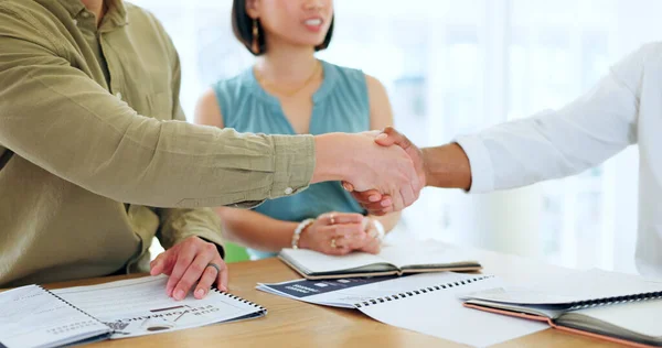 Business people, hand shake and documents for partnership deal, contract or agreement in company office. Shaking hands, men and woman after negotiation, meeting or collaboration for corporate work.