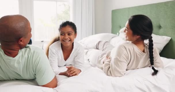 快乐的男人 女人和孩子在床上 共度美好时光 多种族家庭在家里放松 在早上的谈话中 和妈妈 爸爸和女孩在卧室里讨论 亲吻和微笑 — 图库视频影像