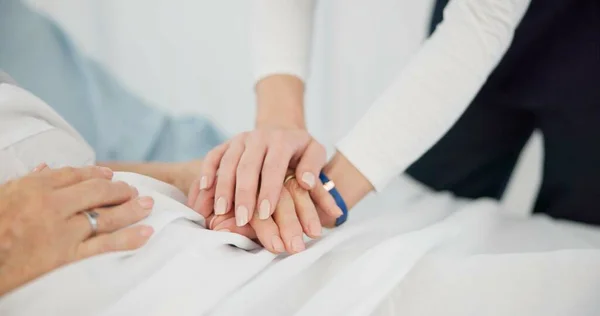People, holding hands and care for life, support or trust in commitment, understanding or grief at hospital. Closeup of women touching in healthcare for loss, illness or virus on bed at the clinic.
