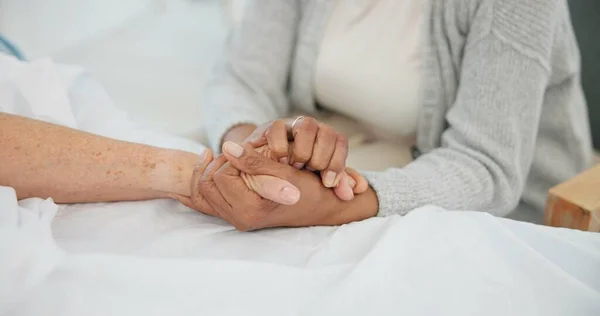 Senior couple, support and holding hands in hospital with love and care at clinic. Elderly patient, kindness and marriage with trust and healthcare with medical help and homecare with empathy.