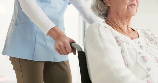 Nurse, senior woman and push wheelchair with helping hand, care and support for rehabilitation in clinic. Medic, elderly person with disability and mobility with empathy, kindness and retirement.