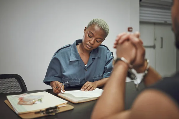 囚犯和女警官在警察局撰写社会公正法律报告 安全和戴手铐的男性小偷在审讯室与女警交谈 — 图库照片
