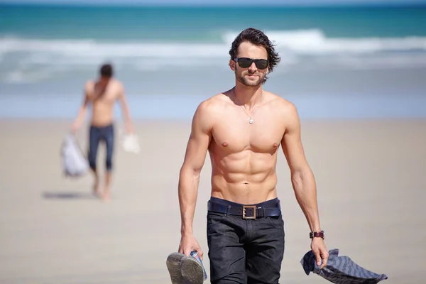 ポートレート サングラス 休暇での冒険のためのビーチの男の体 若者は休日のための熱帯海岸で海や海でシャツを着ていない — ストック写真