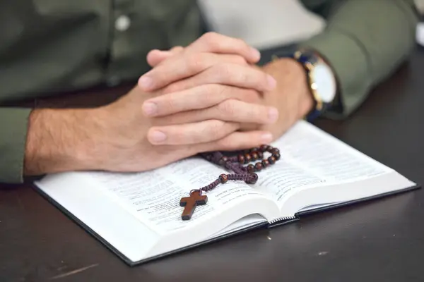Bible, cross and hands, person praying with religion, faith and gratitude with trust in God. Crucifix, rosary beads and Christian holy book, spiritual and Jesus with prayer, belief and worship.