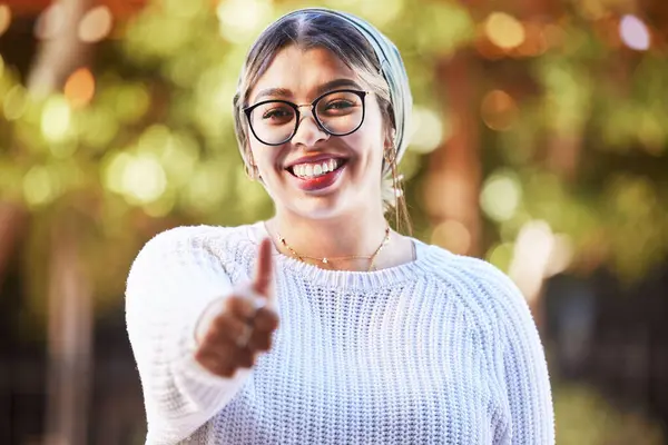 Young woman, thumbs up in portrait and smile, agreement and yes emoji with like sign and happiness. Deal, support and positive feedback, female person with review and good luck, opinion and vote.