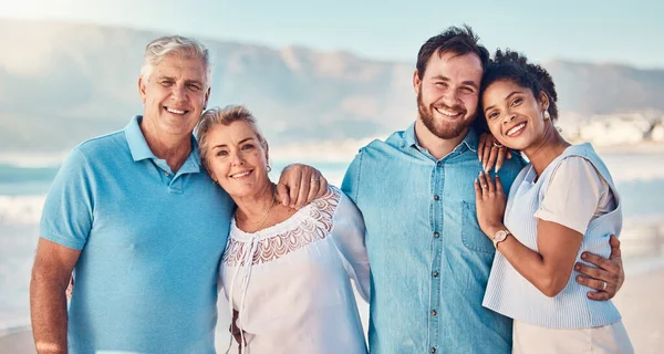 Portrait, diversity and love with a blended family on the beach together in summer for vacation or holiday. Senior parents, smile and in laws with a group of people standing y by the ocean or sea.