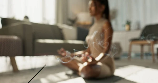 Woman, yoga and incense on floor, lotus or peace for chakra balance, relax or breath in home living room. Girl, meditation or spiritual with zen, smoke or workout for wellness, fitness or mindfulness.