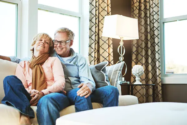 Relax, home and mature couple on sofa hug for bonding, healthy relationship and marriage. Retirement, happy and senior man and woman smile on couch for love, commitment and embrace in living room.