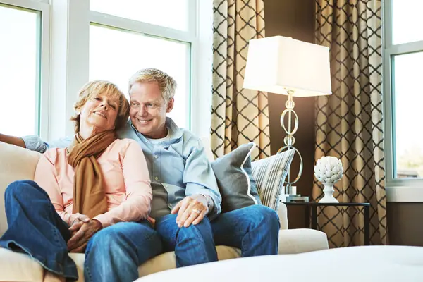 Relax, love and mature couple on sofa hug for bonding, healthy relationship and marriage. Retirement, home and senior man and woman on couch for embrace, commitment and happiness in living room.
