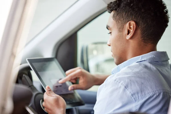 Tablet, navigation and a man driving a car while searching online for directions to a location as a driver. Map, technology and app with a young male sitting in a vehicle for transport or travel.
