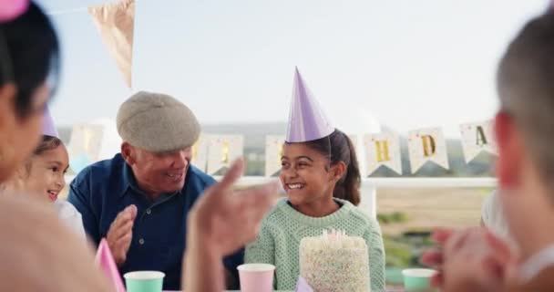 誕生日パーティー 興奮し 庭で彼女のケーキの上にろうそくを吹くために女の子のための家族の拍手の手 一緒に屋外イベントでお祝いの幸せ 笑顔と若い子供たちとグループ — ストック動画