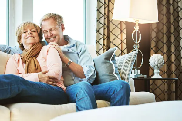 Relax, sofa and happy old couple in home for bonding, healthy relationship and marriage. Retirement, smile and senior man and woman hug on couch for love, commitment and happiness in living room.