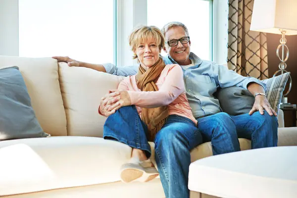Relax, retirement and portrait of couple on sofa for bonding, healthy relationship and marriage. Happy, home and senior man and woman hug on couch for love, commitment and embrace in living room.