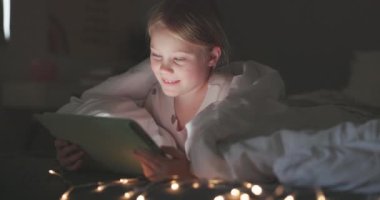 Mutlu kız, çocuk ve tablet gece yatak odasında online oyunlar, kitap hikayeleri ya da eğitici internet uygulamaları için. Çocuk, dijital teknoloji veya çizgi film, medya veya battaniye ile rahatlamak için bağlantı.