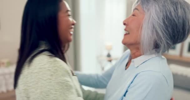 微笑和一个年长的亚洲女人在一个家的客厅里拥抱她的女儿 退休和一个在公寓里拥抱她快乐母亲的成年孩子 — 图库视频影像