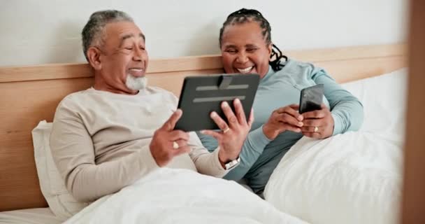 ベッドで電話 タブレット 成熟したカップル 朝にタイピングと会話 自宅でインターネット ソーシャルメディア デジタルモバイルアプリでテクノロジー 幸せな男と異人種間の女性 — ストック動画