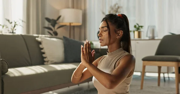 Woman, yoga and meditation with praying hands in living room for zen, mental health and healthy at home. Indian, person or breath with peace to relax, chakra training and spiritual wellness on floor.