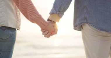 Çift, gün batımı ve kumsalda aşk, ilgi ve aşk için el ele tutuşmak. Okyanus, kadın ve erkek birlikte evlilik, ortaklık ve deniz kıyısındaki ilişki için sadakat.