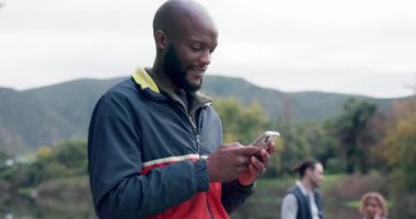 African man, forest and phone with texting, reading and funny meme for camping, adventure or holiday. Gen z guy, smartphone and happy for comic video, web chat or post on social network app in woods.