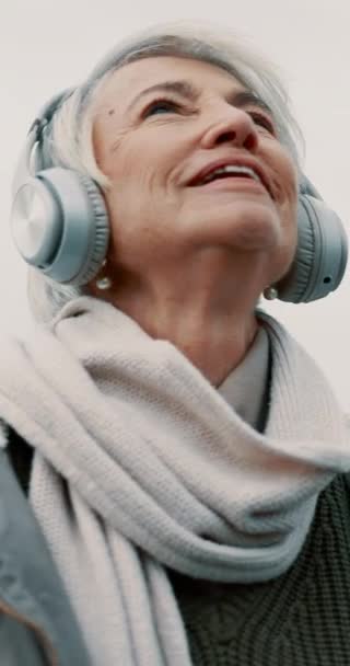 老妇人 带着耳机和室外音乐思考 走路和健康与音频流淌和退休 波德广播 听广播和灵感 女性和记忆与技术 — 图库视频影像