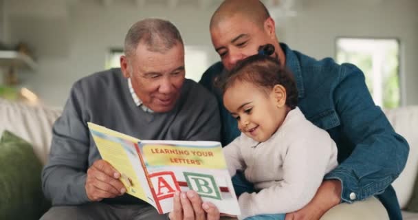 おじいさん お父さん お父さん お子さんは本を読み 質の高い時間を過ごし 学びます ソファーでの開発 男性の親と老人 子供との文学と知識とリラックス — ストック動画
