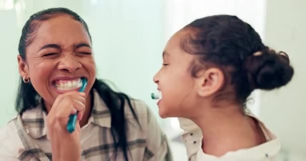 母亲和女儿用牙刷和有趣的东西 牙齿健康和早上的例行公事带着笑声 卫生和嬉闹 妇女和少女 家庭口腔护理和清洁嘴 — 图库视频影像