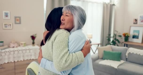 そして高齢のアジアの女性が訪問中に家のリビングルームで娘を抱きしめました そしてアパートで幸せな母親を抱きしめる大人の子供 — ストック動画