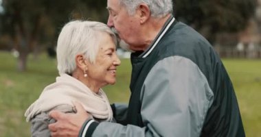 Aşk, gülümseme ve yaşlı bir çiftin emeklilik sırasında romantik bir randevu için parkta kucaklaşması. Mutluluk, destek ve yaşlı bir adam ve kadın romantizm için bahçede kaynaşıyorlar..