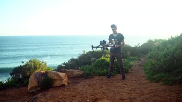 机器人和一个在夏天驾驶无人驾驶飞机飞越海洋拍摄录像的男人 — 图库视频影像