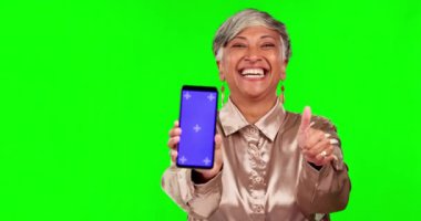 Stüdyoda pazarlama ve reklam teknolojisi üzerine yeşil ekranı olan bir kadın ve telefon var. Happy, gülümse ve son sınıf modelinin cep telefonlu ve takip cihazlı portresi.