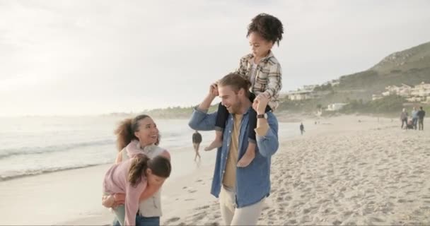 ピギーバック 子供とビーチでブレンドされた家族は 旅行や休暇のために砂の上を一緒に歩いています 母と父と子供たちは海のそばで絆を深めながら夏の海岸で休暇を過ごす — ストック動画